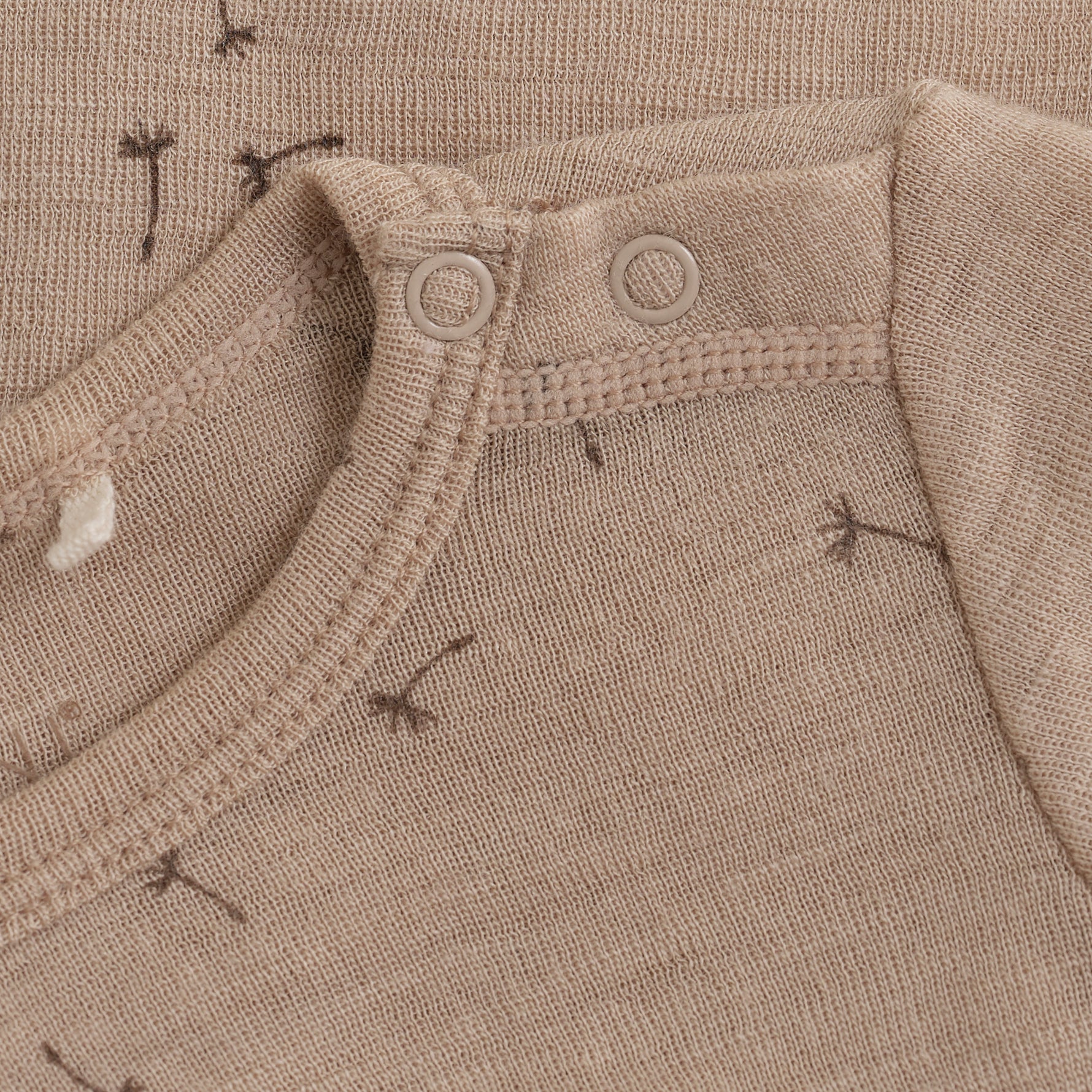 Entdecken Sie den Komfort und die Weichheit von unserem langarm Body in beige mit einem süßen Pusteblumenprint aus hochwertiger Wolle und Seide. Perfekt für empfindliche Haut und optimal für kalte Tage