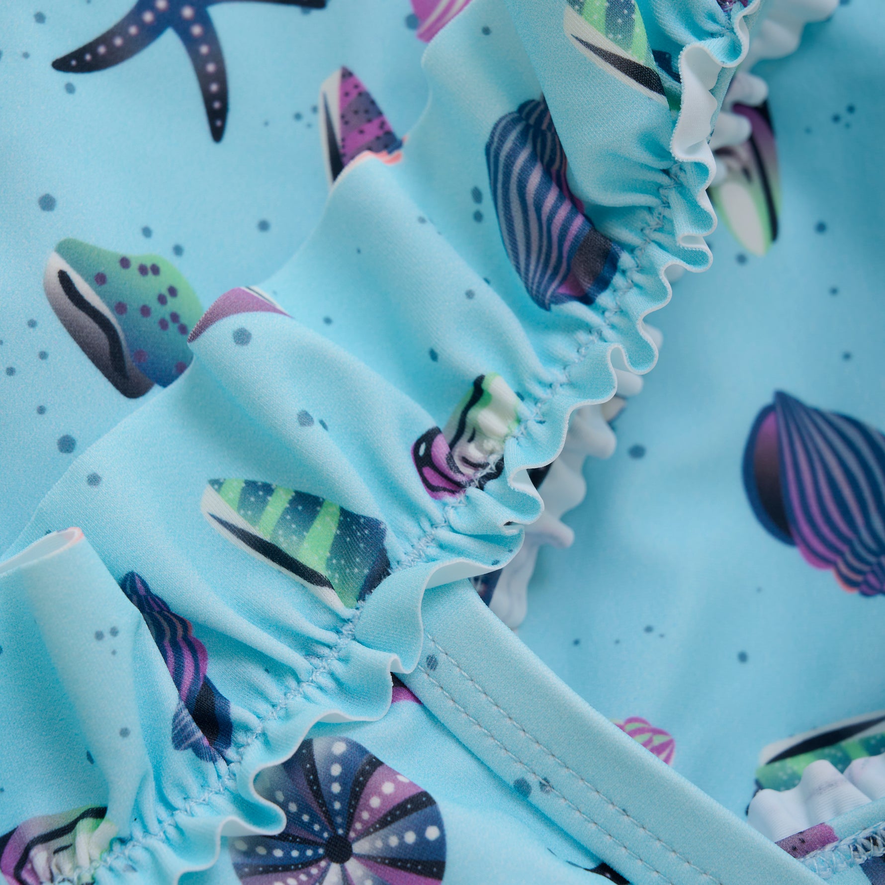 Dieser blaue Badeanzug von Color Kids besticht durch ein maritimes Muster und sorgt für einen fröhlichen Auftritt am Wasser.