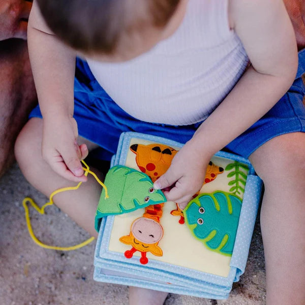 Begib dich auf eine spannende Reise in die faszinierende Wildnis des Mini Quiet Book "Jolly Jungle" von Jolly Designs! Dieses handgefertigte Buch ist perfekt für kleine Entdecker ab 18 Monaten und bietet sicheren Spielspaß aus kinderfreundlichen, OEKO-TEX® zertifizierten Materialien. Mit seinen 6 weichen Seiten führt es Kinder in die Welt der Tiere und fördert dabei spielerisch ihre motorischen und kognitiven Fähigkeiten.