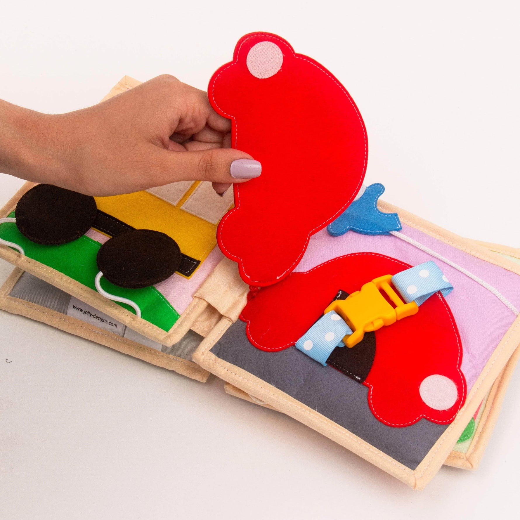 Das Mini Quiet Book Autobahn von Jolly Designs nimmt Kinder ab 2 Jahren mit auf eine fantasievolle Reise durch die Welt der Fahrzeuge. Auf 6 liebevoll handgefertigten Seiten können sie spielerisch Autos, Lokomotiven und Schiffe erkunden. Mit interaktiven Elementen wie Knöpfen, Klettverschlüssen und beweglichen Teilen fördert das Buch Feinmotorik, Konzentration und Kreativität und regt die Fantasie sowie die kognitive Entwicklung an.