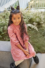 Dieses rosa Kleid von MINYMO ist mit einem fröhlichen Smiley-Motiv versehen und sorgt für gute Laune.