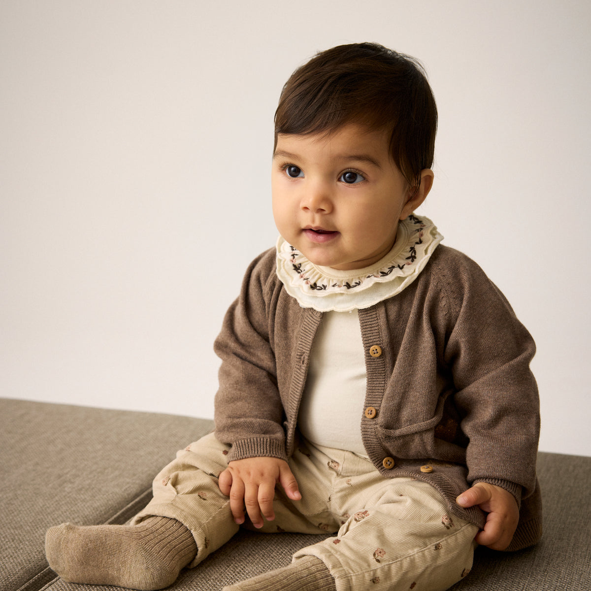 Ein wunderschöner brauner Knit Cardigan von Minymo mit zarten Herzmotiven und Rüschenverzierungen – perfekt für einfache gemütliche Tage und viele vielseitige Kombinationen.