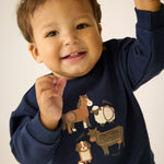 Gemütliches Sweatshirt mit langen Ärmeln in dunklem Blau – perfekt für kleine Abenteurer. Das hochwertige Minymo-Design besticht durch niedliche Farmtier-Motive, die Kinderherzen höher schlagen lassen. Die Mischung aus 95% Baumwolle und 5% Elastane sorgt für optimalen Tragekomfort und Bewegungsfreiheit den ganzen Tag über.