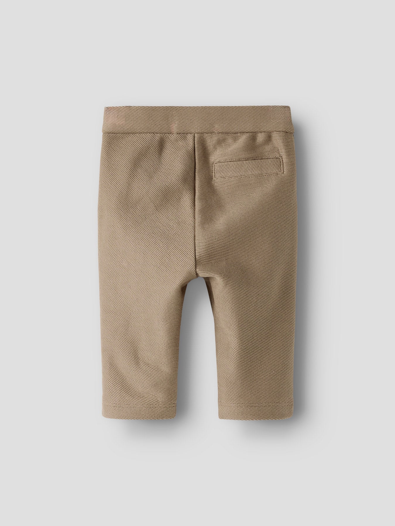 Diese elegante Hose von Lil'Atelier, perfekt kombiniert mit dem Bodyhemd, schafft einen stilvollen Look für modische Babyjungen.
