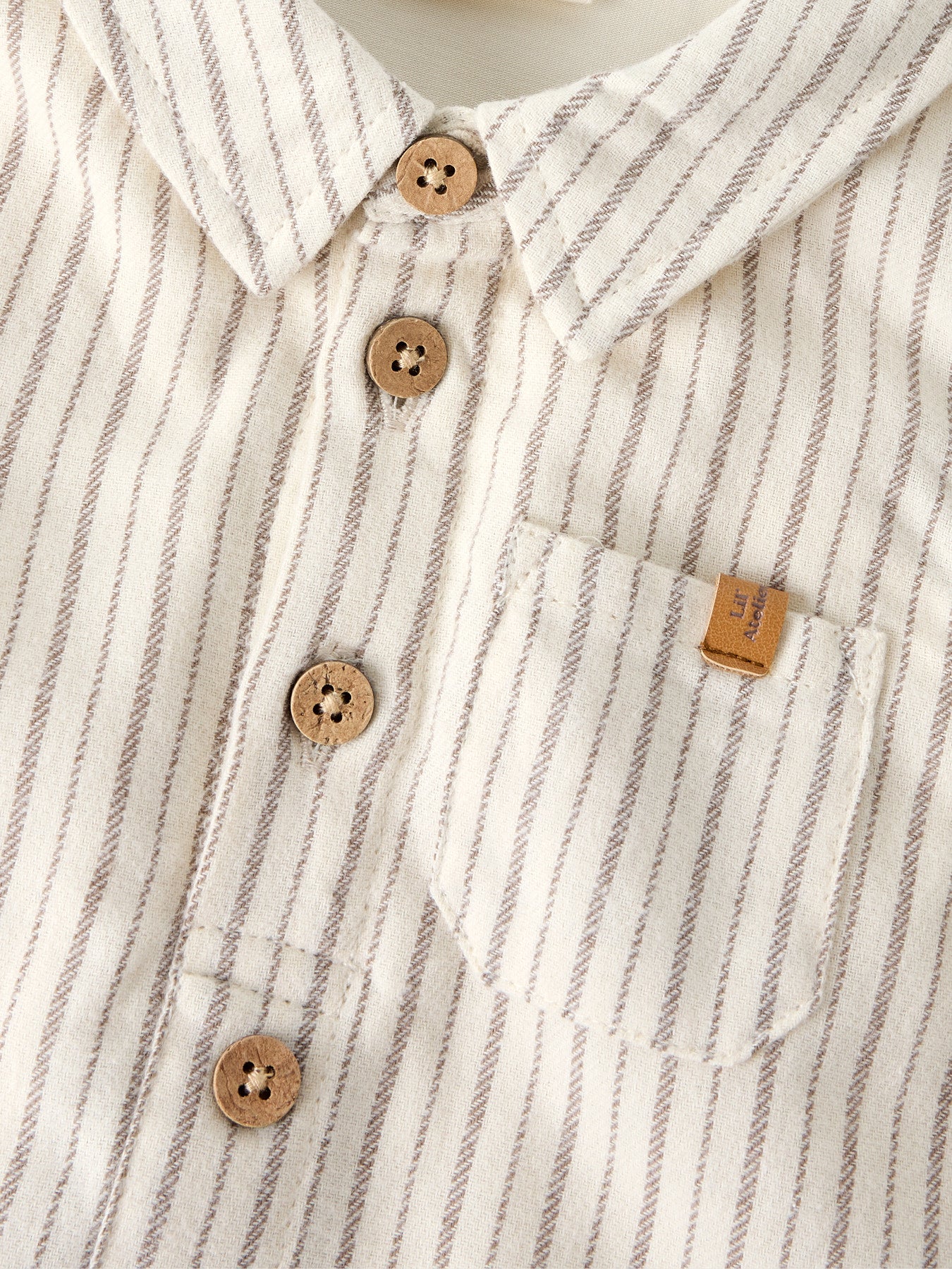 Beiger Hemdbody von Lil'Atelier mit feinen Streifen für einen stilvollen Auftritt.