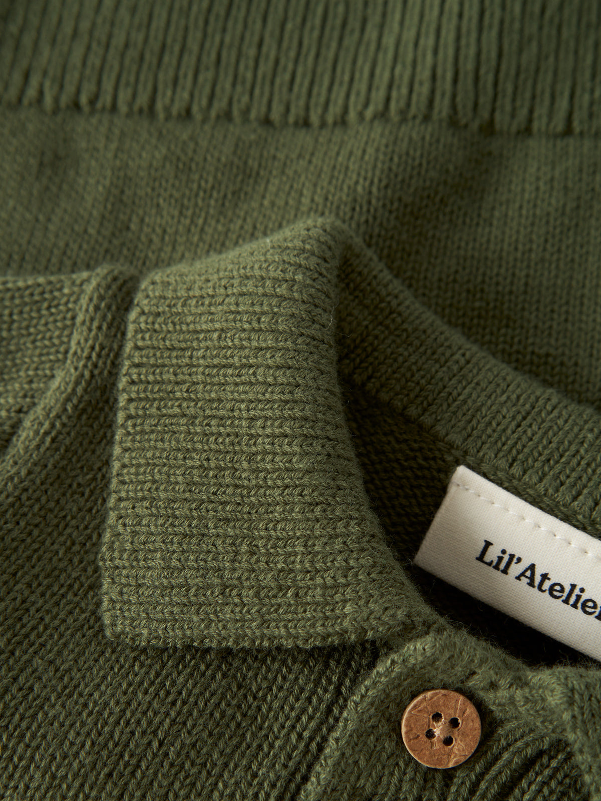 Das dunkelgrüne Knit Polo-Shirt von Lil'Atelier besticht durch seine hochwertige Verarbeitung und nachhaltige Materialzusammensetzung. Die Kombination aus 80% Bio-Baumwolle und 20% recycelter Baumwolle sorgt für optimalen Tragekomfort und Langlebigkeit.&nbsp;