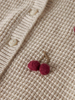 Die beige Strickweste von name it besticht durch ihr zeitloses Design und die niedlichen kleinen Kirschen-Details. Das Modell überzeugt mit einer angenehmen Passform und eignet sich perfekt für vielseitige Styling-Möglichkeiten – ob zu Jeans, Kleidern oder Röcken. Das Oberteil wird aus 100% Bio-Baumwolle gefertigt und bietet damit höchsten Tragekomfort sowie Hautfreundlichkeit. Die nachhaltige Materialwahl macht diese Weste zu einer verantwortungsvollen Wahl für bewusste Käufer. Ideal für Übergangsjahreszei