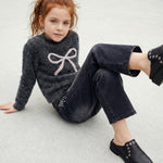 Ein weiches Knit Pullover mit funkelndem Glitzer und zierlichem Schleifenmotiv – perfekt für stilbewusste Kids. Die hochwertige Mischung aus Nylon und Metallic Fiber sorgt für Glanz und Strapazierfähigkeit. Ideal für besondere Anlässe oder als Lieblingsstück im Alltag.