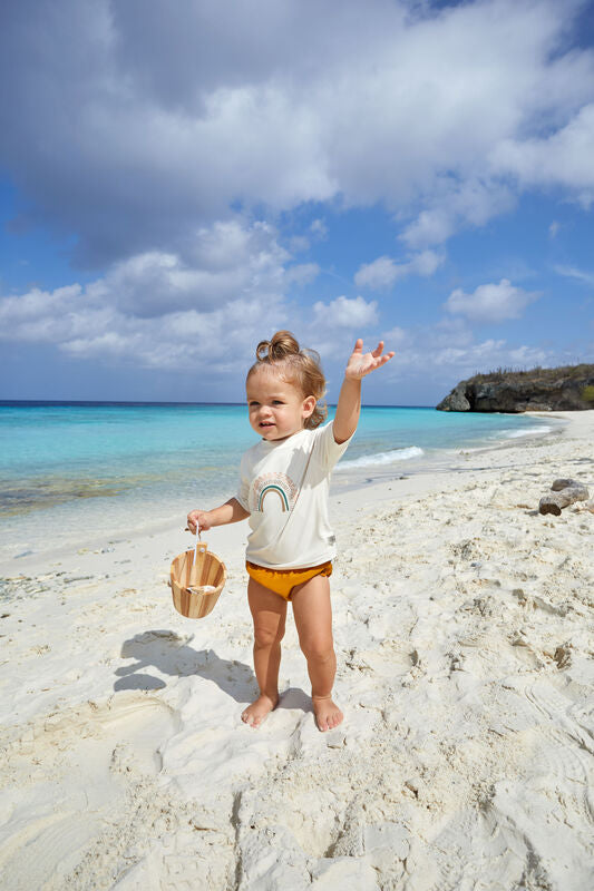 Das weiße, kurzärmelige Kinder UV Shirt mit UV-Schutz 60 kommt mit einem Regenbogen und extra weichem Stoff. Das atmungsaktive und schnelltrocknende Material sorgt für eine angenehme Passform und Badespaß.