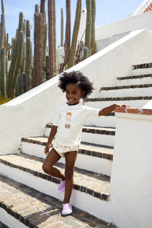 Das weiße, kurzärmelige Kinder UV Shirt mit UV-Schutz 60 kommt mit einem Kamel Print und extra weichem Stoff. Das atmungsaktive und schnelltrocknende Material sorgt für eine angenehme Passform und Badespaß