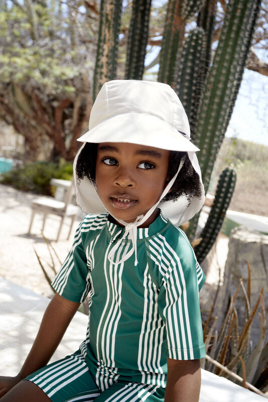 Die weiße Kinder Schirmmütze mit extra langem Nackenschutz schützt dank UV Schutz 80 die empfindliche Kopfhaut. Das schnelltrocknende Obermaterial und die niedlichen Prints sorgen für unbeschwerte Sommertage.
