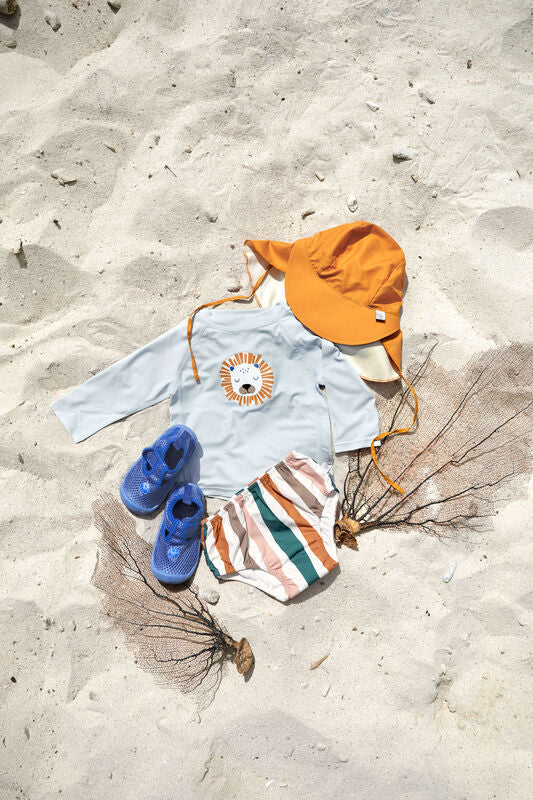 Das hellblaue, langärmelige Kinder UV Shirt mit UV-Schutz 60 kommt mit einem Löwen Print und extra weichem Stoff. Das atmungsaktive und schnelltrocknende Material sorgt für eine angenehme Passform und Badespaß