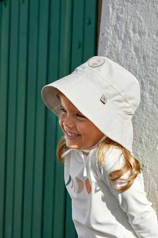 Das weiße, langärmelige Kinder UV Shirt mit UV-Schutz 60 kommt mit einem Mond Print und extra weichem Stoff. Das atmungsaktive und schnelltrocknende Material sorgt für eine angenehme Passform und Badespaß
