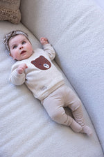 Dieser beiger Pullover aus der Wild World Kollektion von Feetje besticht durch ein edles, flauschiges braunes Bärenmotiv und verbindet Komfort mit stilvoller Eleganz.