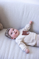 Dieser beiger Pullover aus der Wild World Kollektion von Feetje besticht durch ein edles, flauschiges braunes Bärenmotiv und verbindet Komfort mit stilvoller Eleganz.