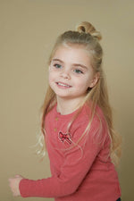 Dieses rosa-rote, gerippte Langarmshirt mit einer zarten Schleife stammt aus der Queen Of Hearts Kollektion von Jubel und bietet einen charmanten, bequemen Look für jeden Tag.