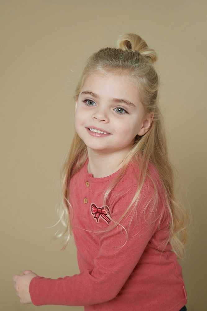 Dieses rosa-rote, gerippte Langarmshirt mit einer zarten Schleife stammt aus der Queen Of Hearts Kollektion von Jubel und bietet einen charmanten, bequemen Look für jeden Tag.