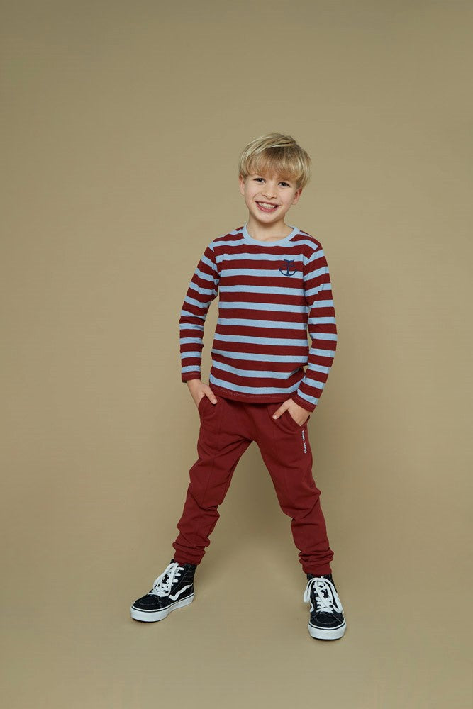 Dieses rot-blaue, gestreifte Langarmshirt aus der Waves and Whales Kollektion von Sturdy überzeugt mit seinem gerippten Material und einem dezenten Anker-Detail – perfekt für einen maritimen Look mit Stil.