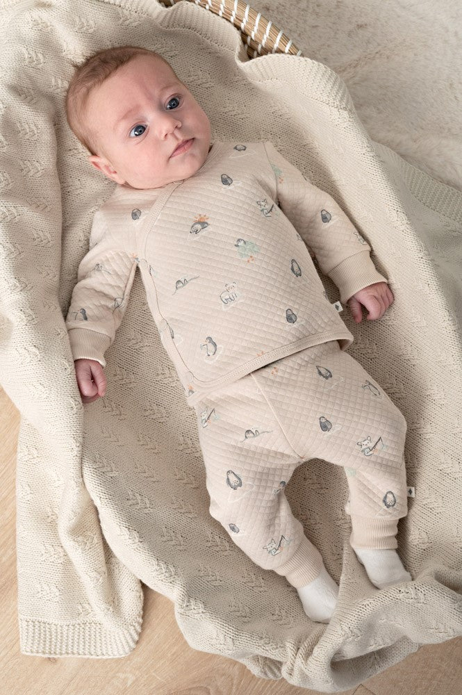 Wickelshirt AOP - Penguin Cuddles von Feetje. Die hochwertige Mischung aus Baumwolle und Polyester sorgt für Strapazierfähigkeit und Komfort. Das stepped double fabric ist besonders weich und angenehm auf empfindlicher Babyhaut. Ideal zum einfachen An- und Ausziehen dank praktischer Wickelfunktion.