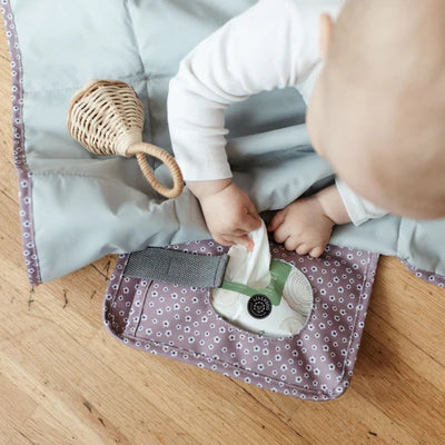 Die Wickelunterlage Blume Berry ist kompakt und praktisch für unterwegs. Mit integrierten Taschen bietet sie Platz für Windeln und Pflegeartikel, sodass alles griffbereit ist. Sie lässt sich einfach am Handgelenk oder Kinderwagen befestigen und nach Gebrauch platzsparend zusammenfalten. So sind Sie jederzeit bestens vorbereitet.
