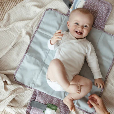 Die Wickelunterlage Blume Berry ist kompakt und praktisch für unterwegs. Mit integrierten Taschen bietet sie Platz für Windeln und Pflegeartikel, sodass alles griffbereit ist. Sie lässt sich einfach am Handgelenk oder Kinderwagen befestigen und nach Gebrauch platzsparend zusammenfalten. So sind Sie jederzeit bestens vorbereitet.